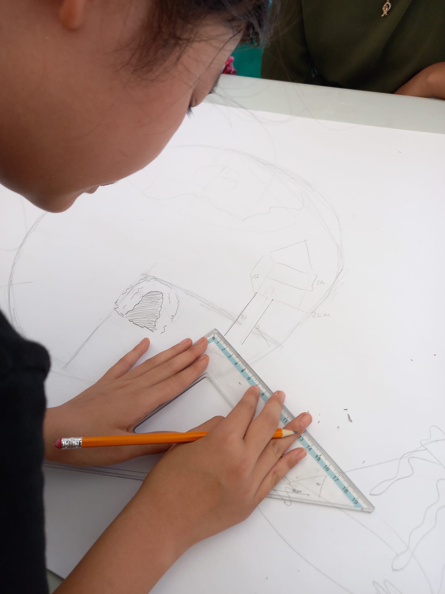 bambina che disegna con un goniometro