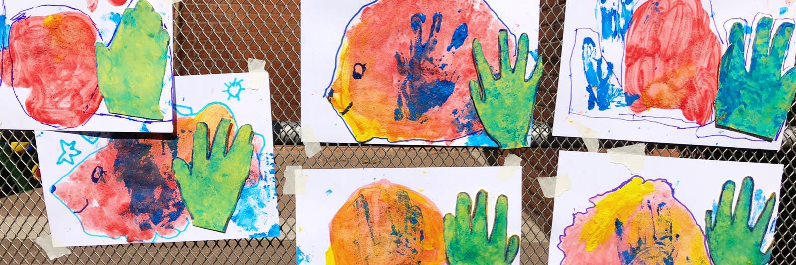 Disegni colorati di bambini appesi ad una parete.
