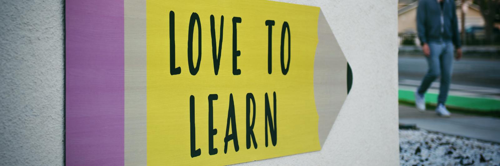 Cartello con scritto "Love to learn"