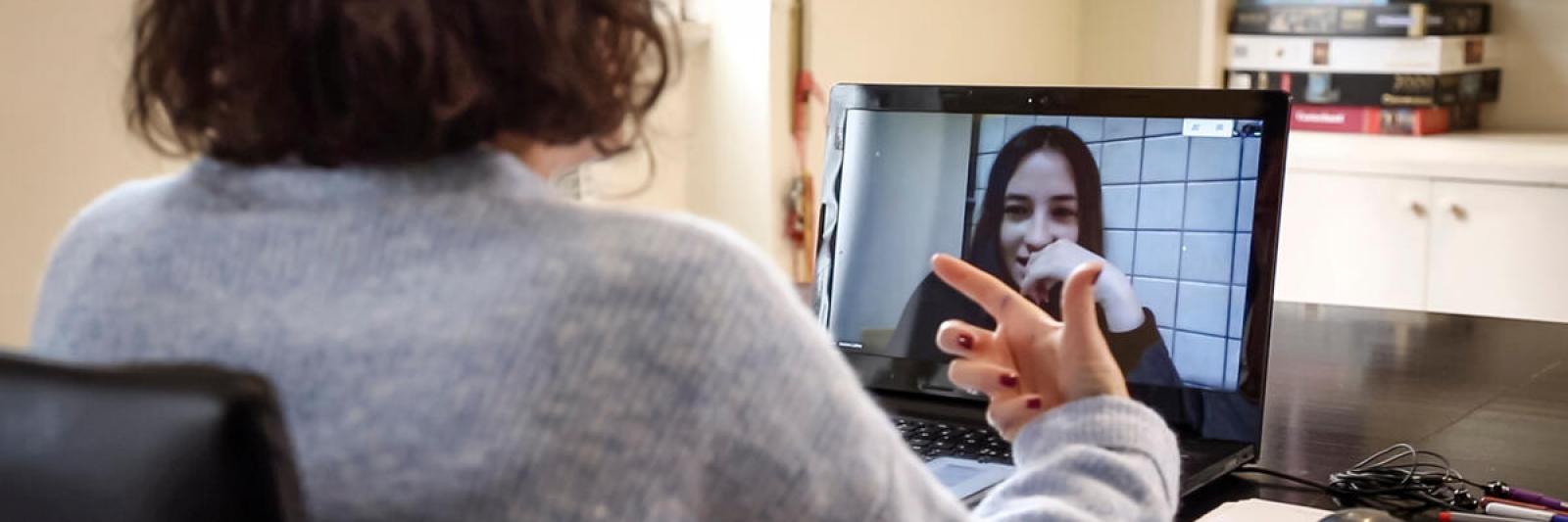 Ragazzo che parla ad un'altra ragazza al computer