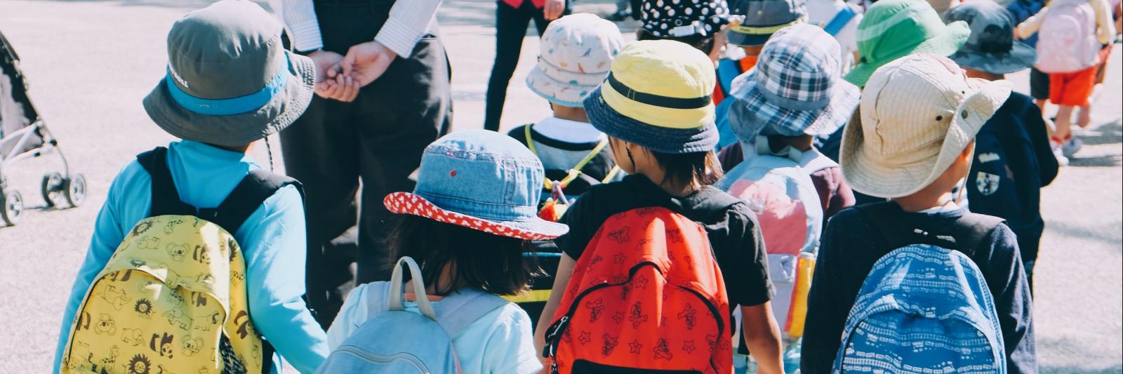 Bambini che camminano con lo zaino di scuola