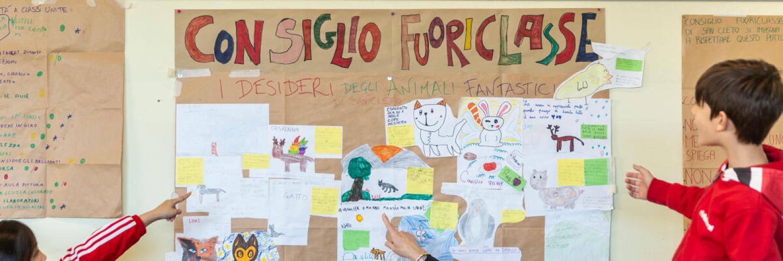 Bambini che indicano un cartellone dei consigli fuoriclasse