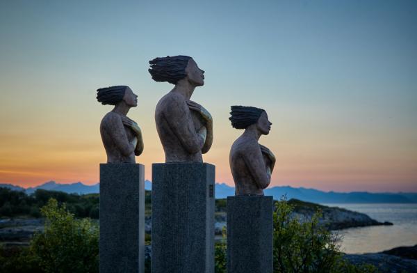 Tre statue di donne, con le mani abbracciate