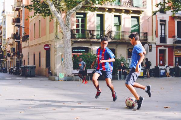 Ragazzi giocano a calcio in una piazza