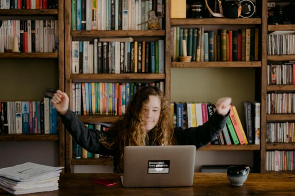 Bambina che esulta davanti ad un computer