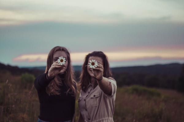 Due ragazze con un fiore in mano