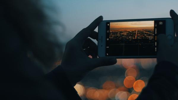 Uno smartphone riprende una città al tramonto
