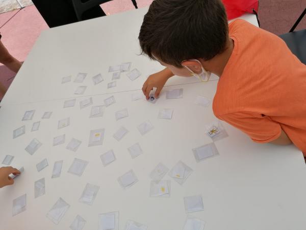 Un bambino gira le carte del memory appoggiate su un tavolo.