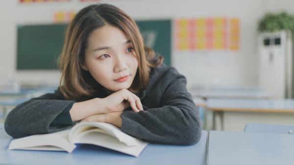 Ragazza con su un libro in un'aula scolastica