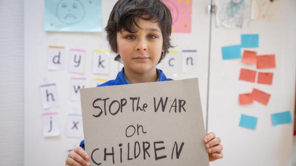 Bambino con cartello "Stop the War on children"