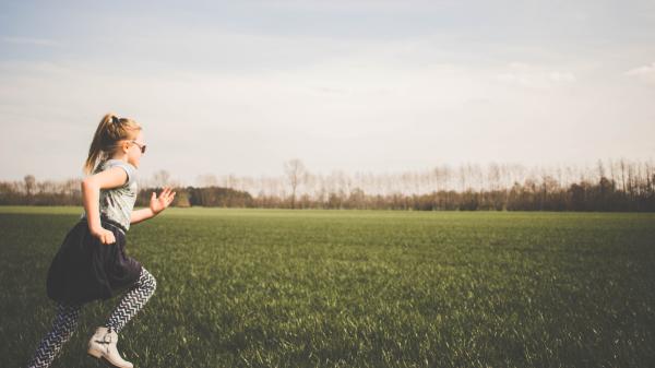 bambina che corre nel prato