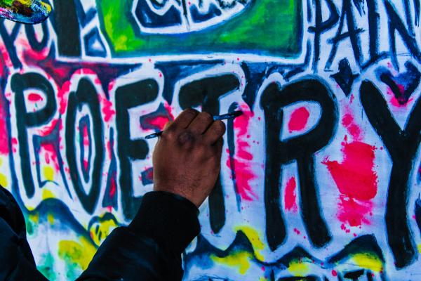 Un ragazzo scrive poetry sul muro