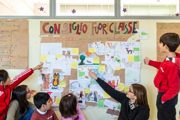 Bambini che indicano un cartellone dei consigli fuoriclasse